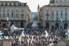 Piazza Castello a Torino affollata di gente tra gli stand bianchi di un festival del cibo
